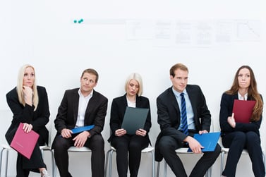 Group of applicants for a vacant post or corporate job sitting in a long line with folders containing their credentials carefully ignoring each other.jpeg